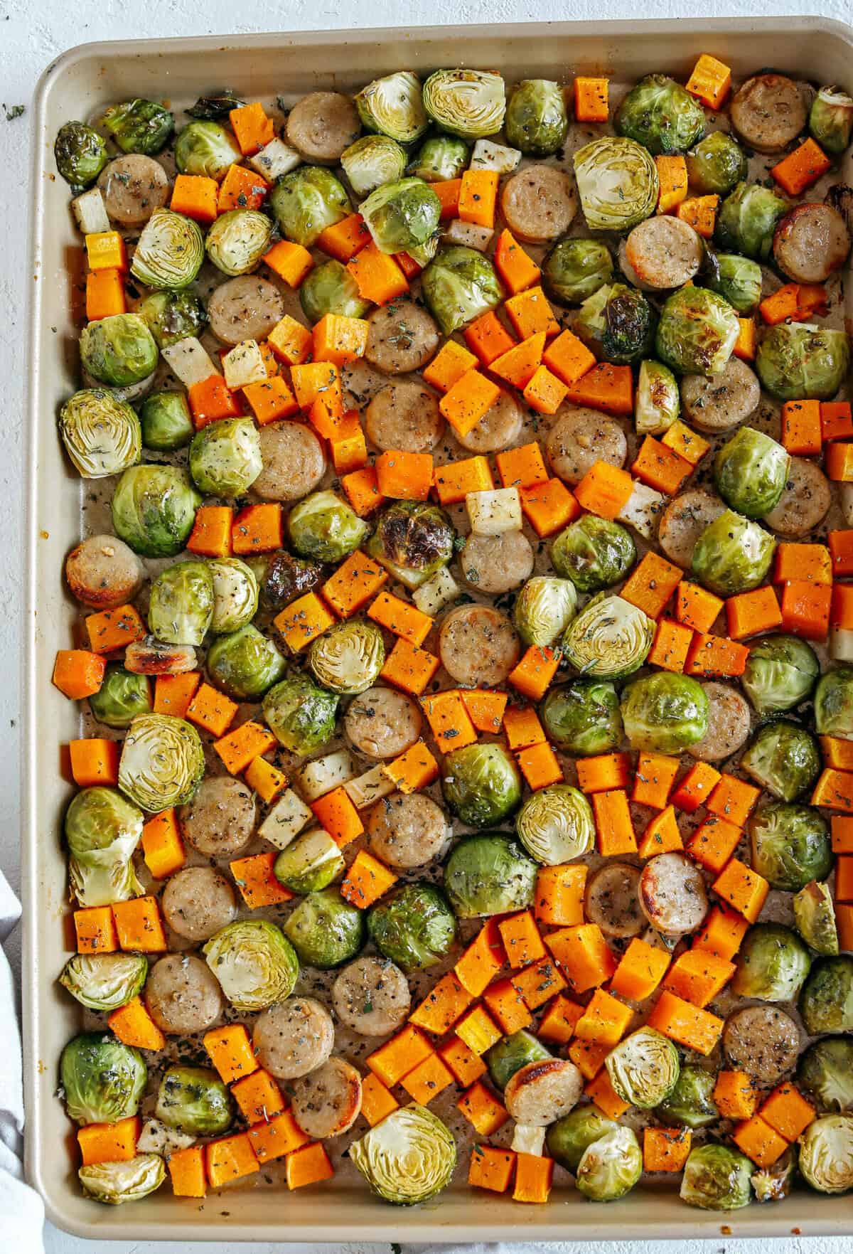 Harvest Sheet Pan Sausage and Veggies loaded with flavorful chicken sausage, butternut squash, brussels sprouts, and apples for a quick and easy dinner made in just 30 minutes! Roasted in a maple mustard glaze and fresh herbs for the perfect fall meal!