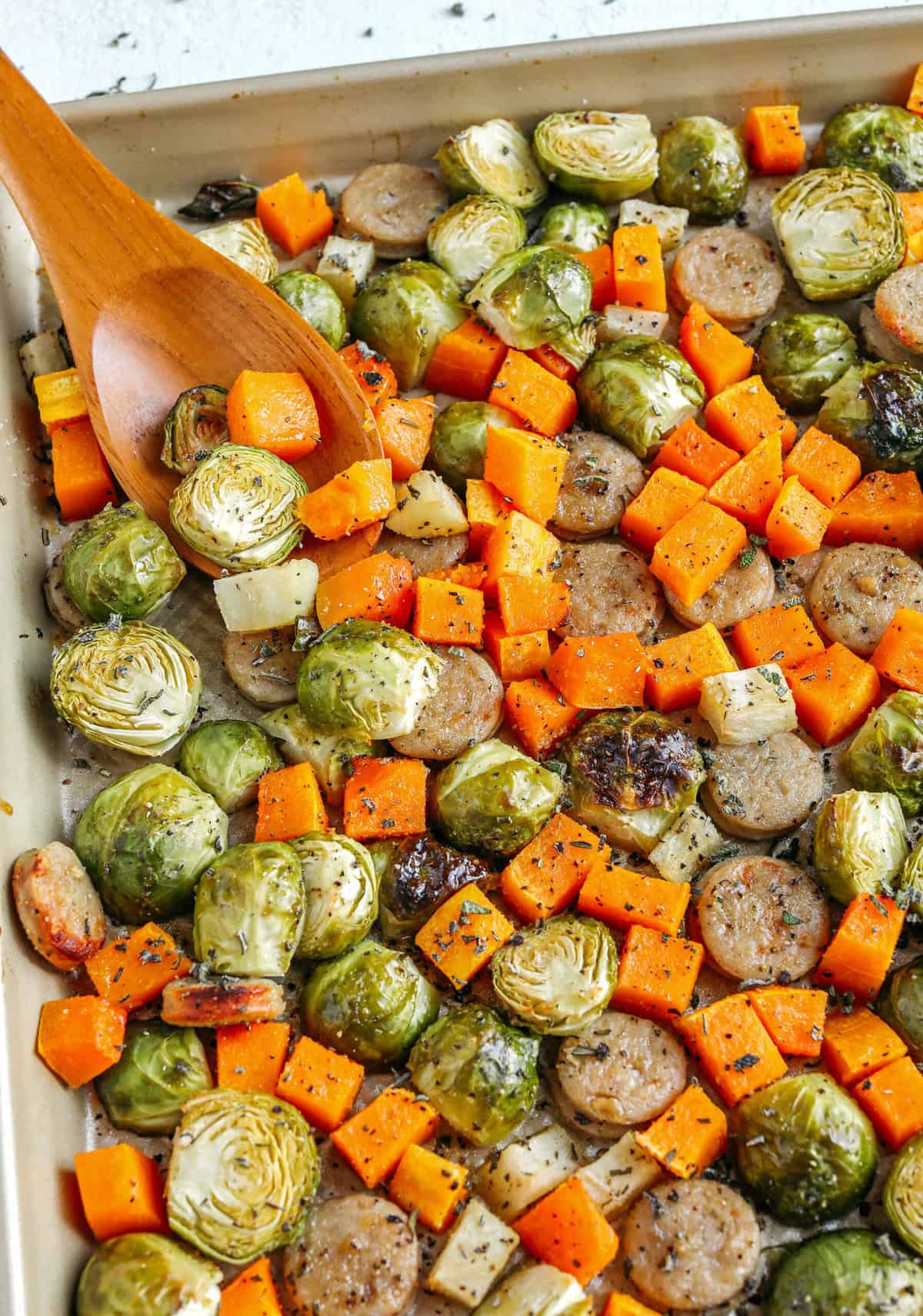 Harvest Sheet Pan Sausage and Veggies loaded with flavorful chicken sausage, butternut squash, brussels sprouts, and apples for a quick and easy dinner made in just 30 minutes! Roasted in a maple mustard glaze and fresh herbs for the perfect fall meal!