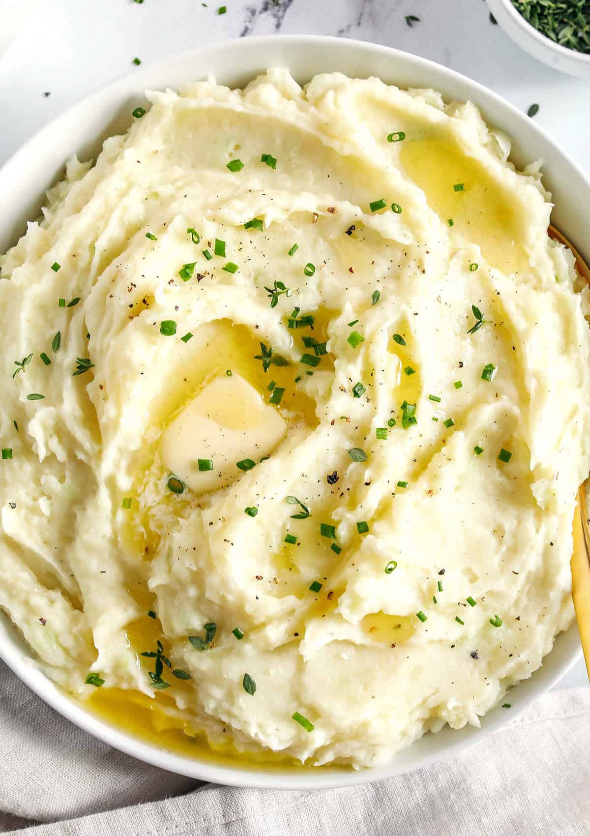These Healthy Mashed Potatoes are creamy, absolutely delicious and made lighter with Greek yogurt, almond milk and a whole head of cauliflower! The perfect side dish for your holiday table or weeknight dinner.
