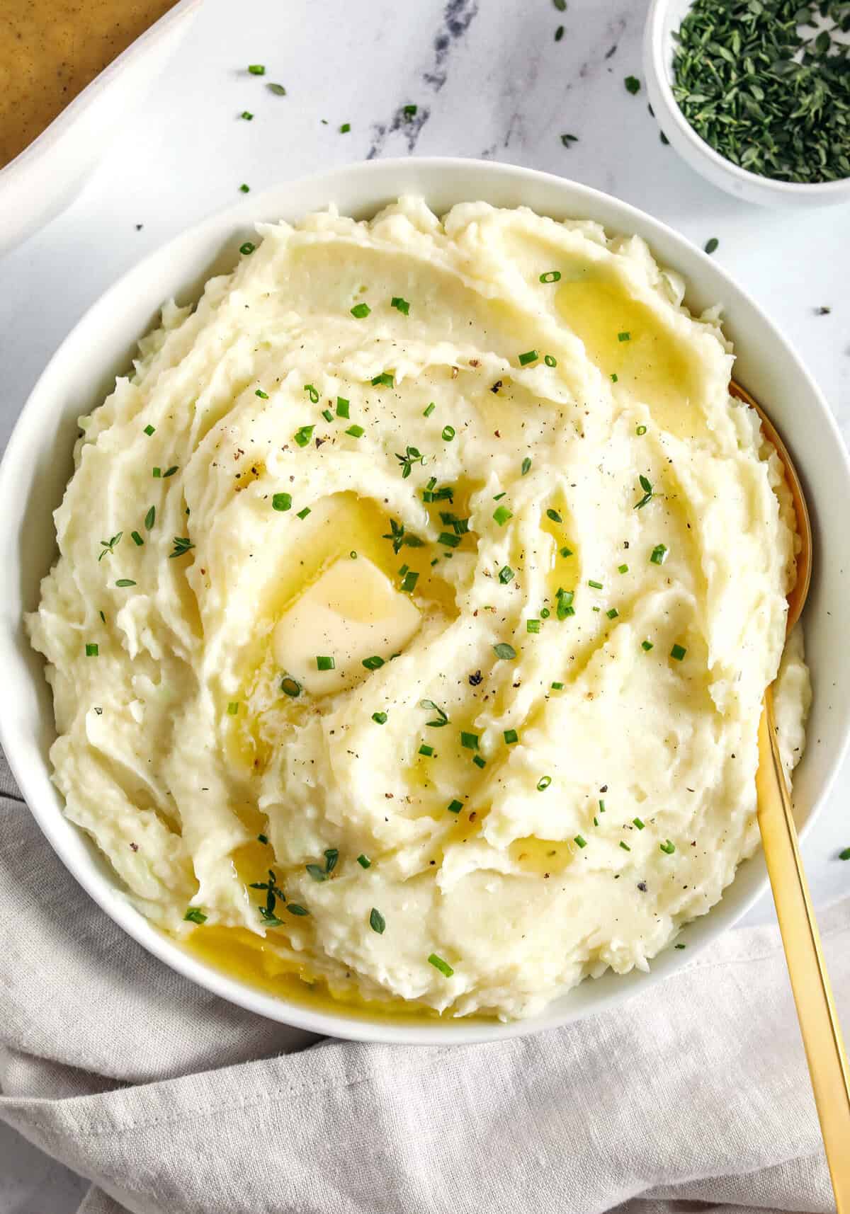 These Healthy Mashed Potatoes are creamy, absolutely delicious and made lighter with Greek yogurt, almond milk and a whole head of cauliflower! The perfect side dish for your holiday table or weeknight dinner.