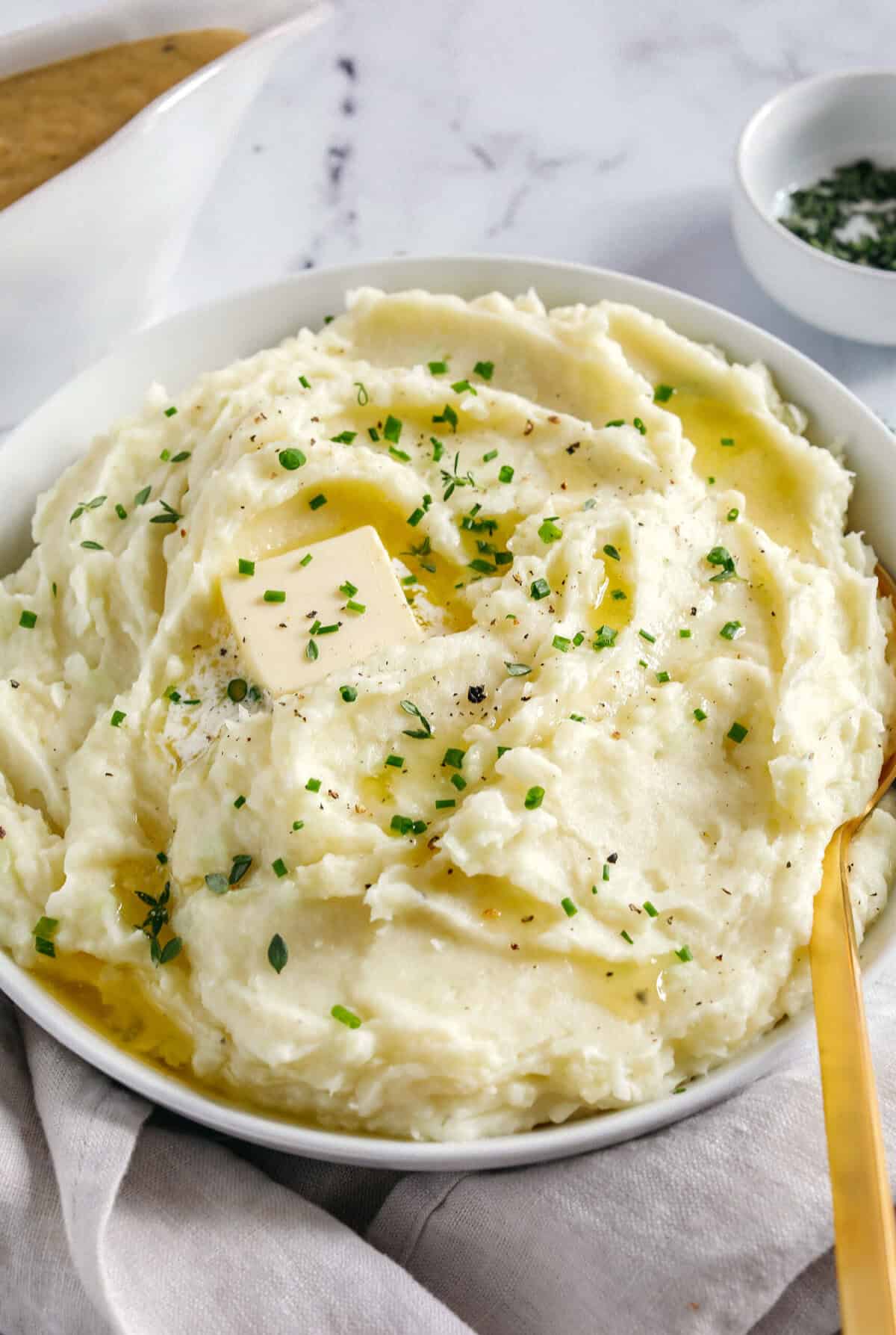 These Healthy Mashed Potatoes are creamy, absolutely delicious and made lighter with Greek yogurt, almond milk and a whole head of cauliflower! The perfect side dish for your holiday table or weeknight dinner.