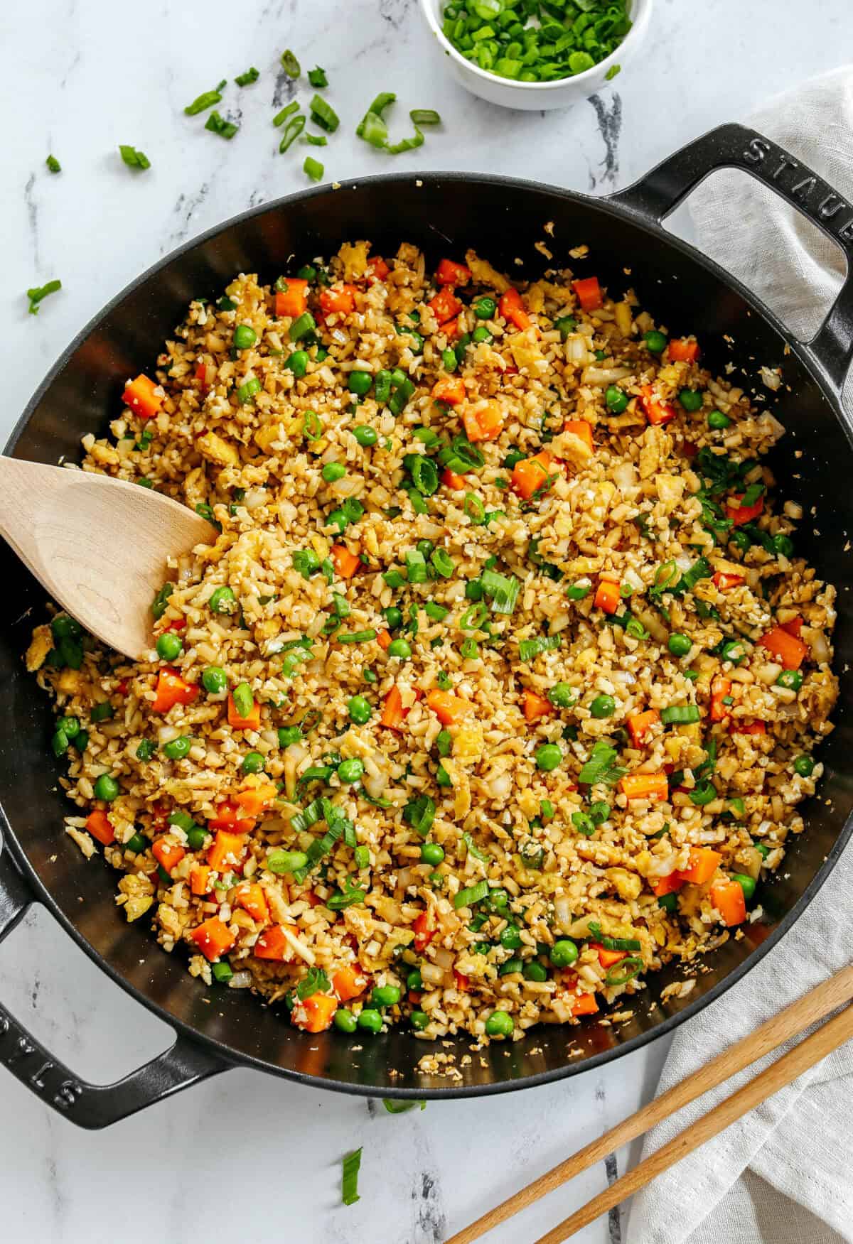 Skip the takeout and enjoy this Healthy Cauliflower Fried Rice in just 15 minutes! Packed with veggies, low in carbs and can be served as a delicious side dish or a main dish with added protein!