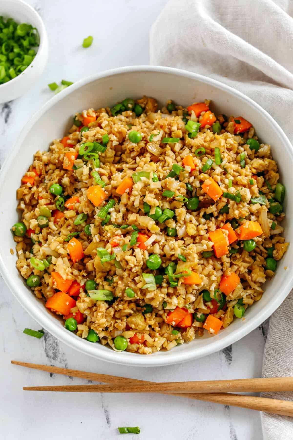 Skip the takeout and enjoy this Healthy Cauliflower Fried Rice in just 15 minutes! Packed with veggies, low in carbs and can be served as a delicious side dish or a main dish with added protein!