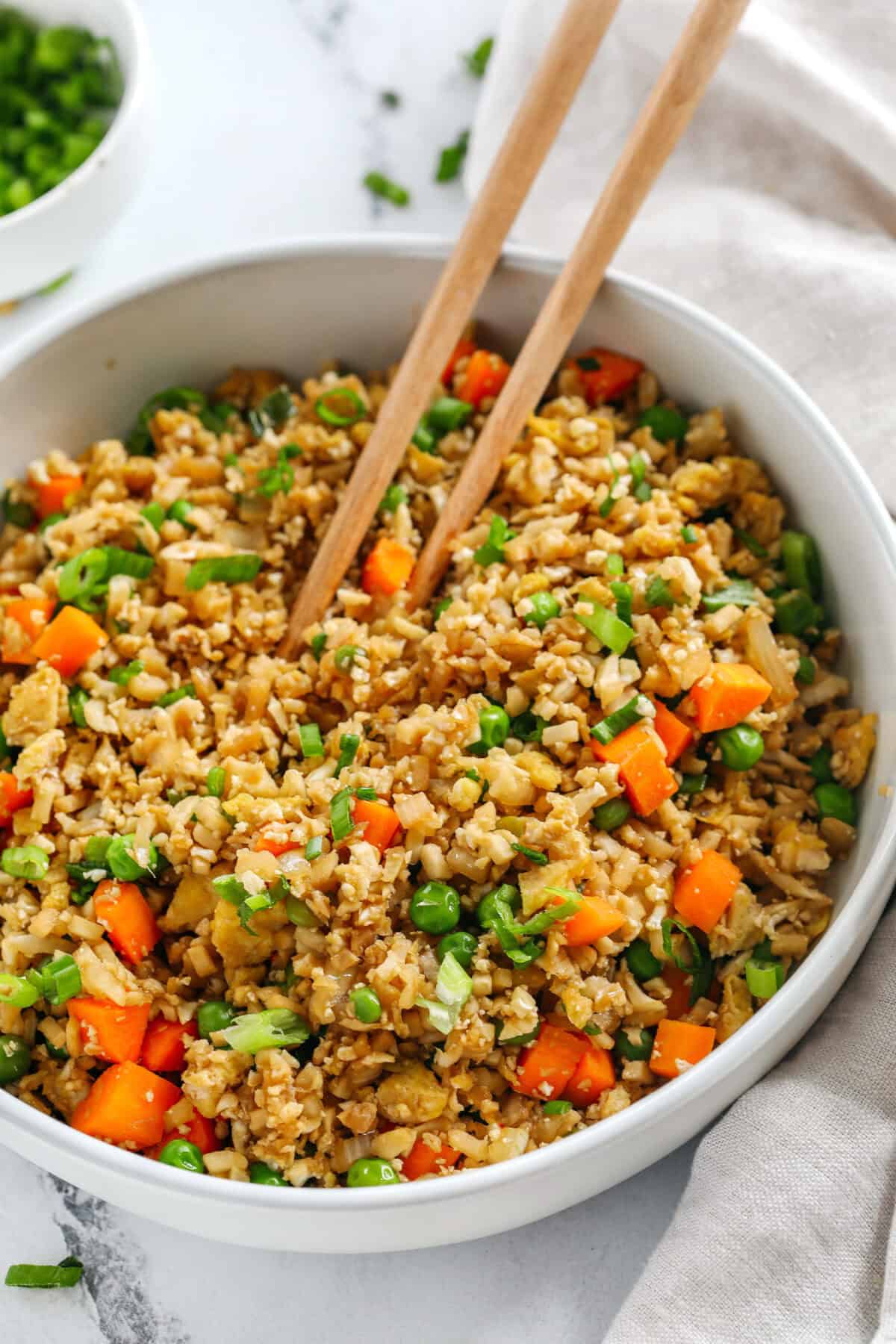 Skip the takeout and enjoy this Healthy Cauliflower Fried Rice in just 15 minutes! Packed with veggies, low in carbs and can be served as a delicious side dish or a main dish with added protein!