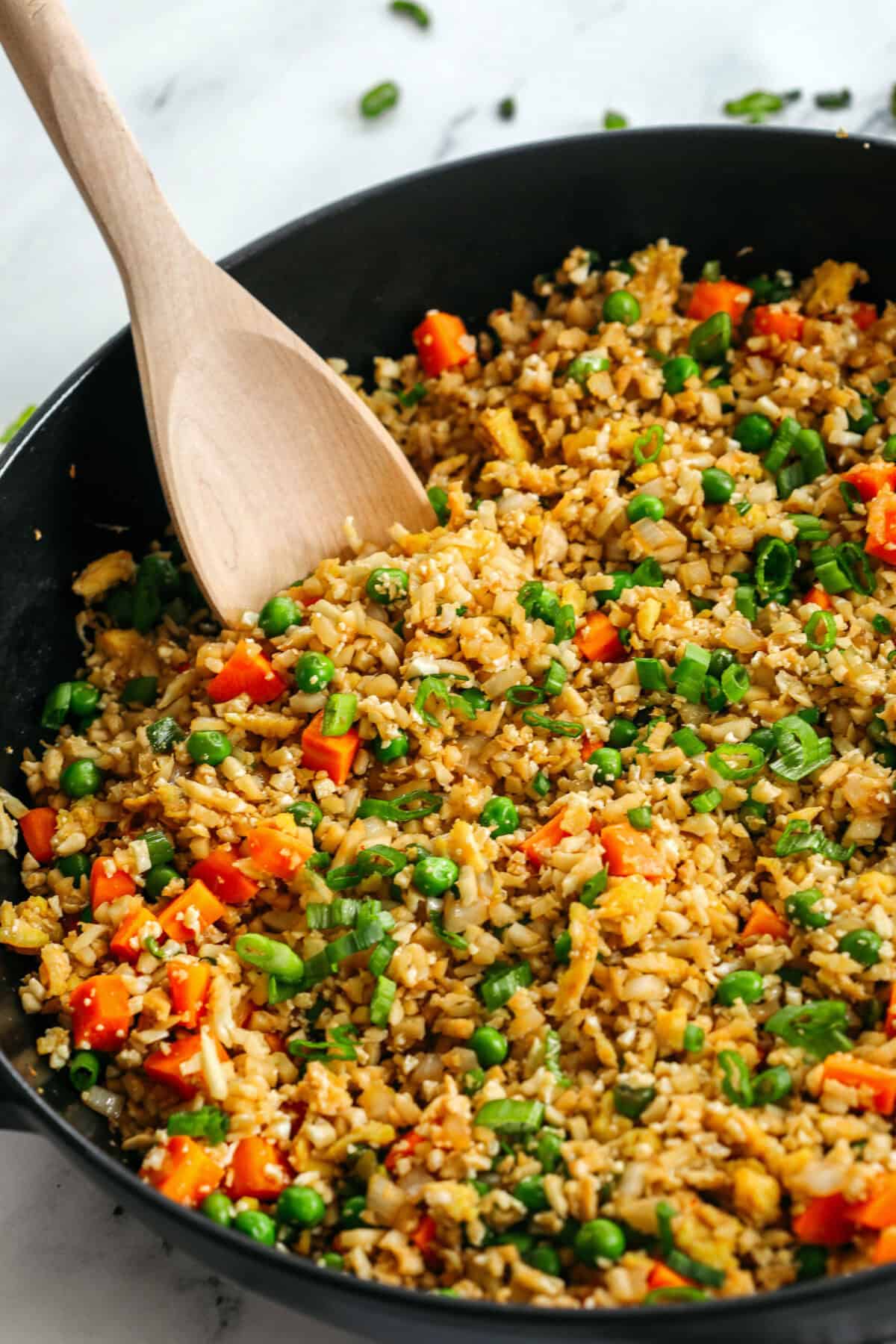Skip the takeout and enjoy this Healthy Cauliflower Fried Rice in just 15 minutes! Packed with veggies, low in carbs and can be served as a delicious side dish or a main dish with added protein!